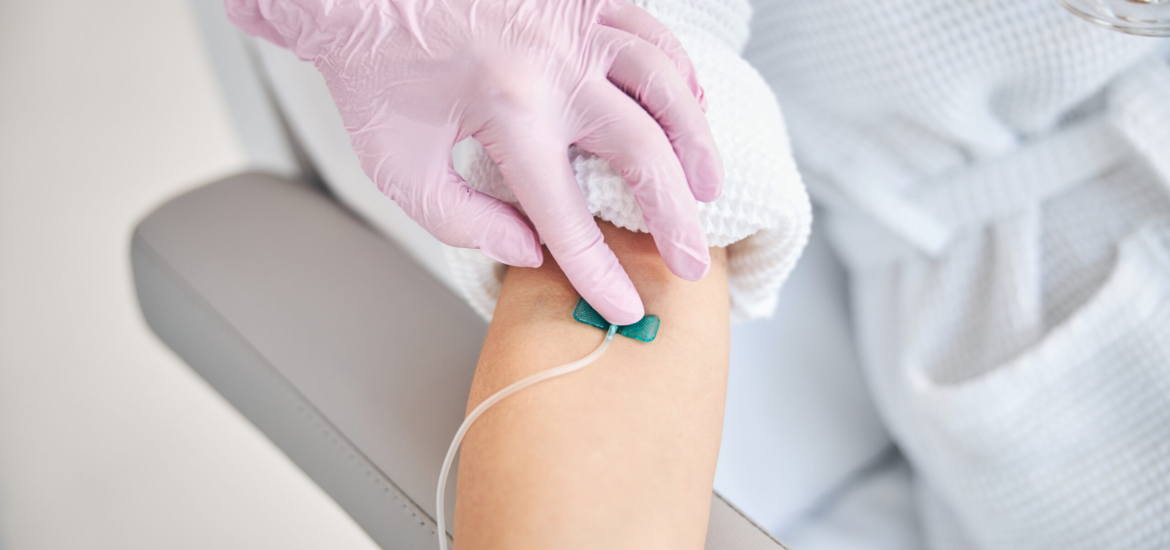 Cropped photo of a female patient lying in bed with a catheter in her vein