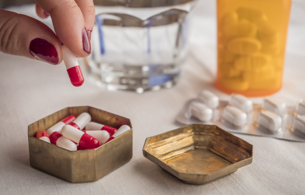 hand-women-take-capsules-red-and-white-in-a-pillbo-2026-01-11-09-41-56-utc