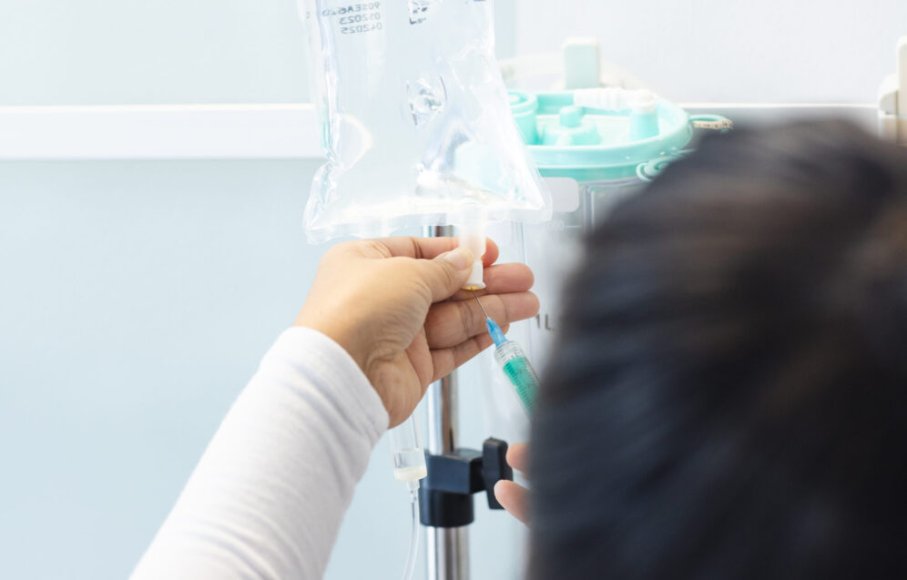 Biracial female doctor preparing drip in sunny hospital room. Medicine, healthcare and medical services, unaltered.