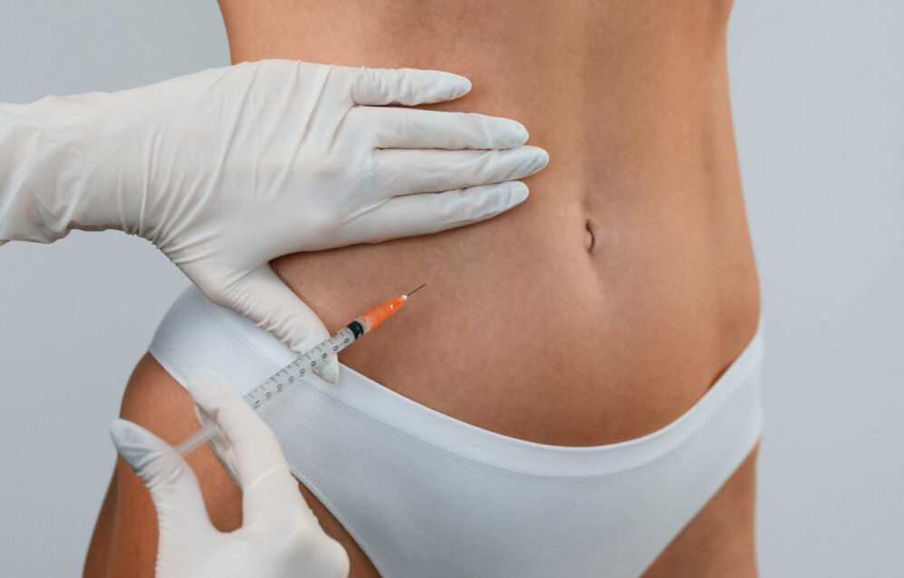 A woman standing indoors and doctor makes injections for rejuvenation. The concept of plastic surgery.